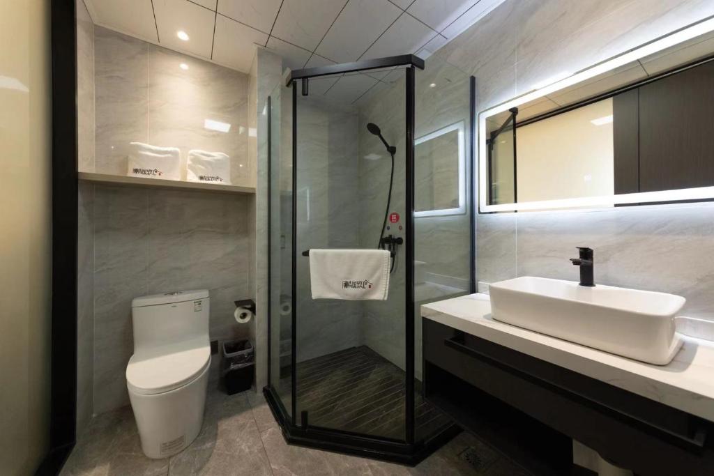a bathroom with a sink and a shower and a toilet at 乌镇闲情逸致精品民宿 in Wujiaqiao