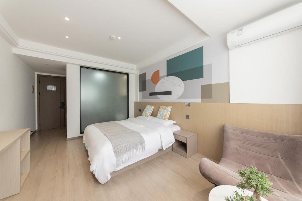 a bedroom with a white bed and a couch at 乌镇闲情逸致精品民宿 in Wujiaqiao