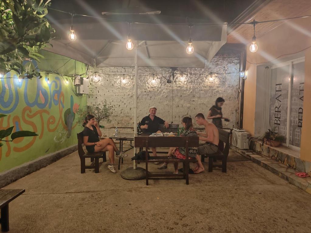 a group of people sitting at a table in a room at D1 Hostel in Tirana