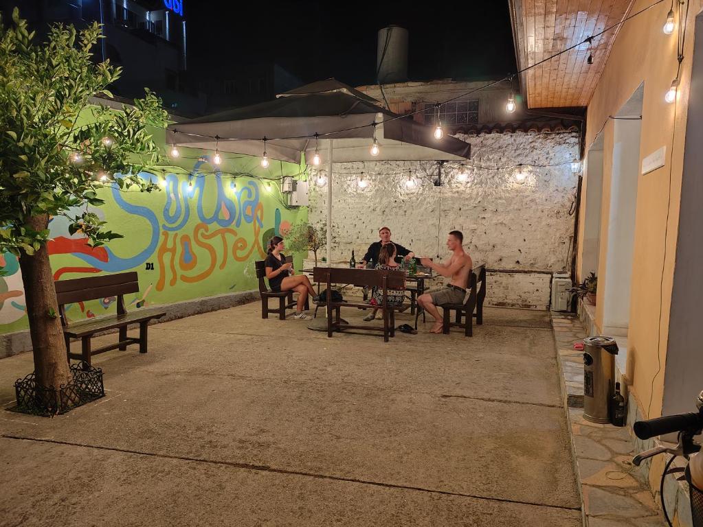 a group of people sitting at a table in a patio at D1 Hostel in Tirana