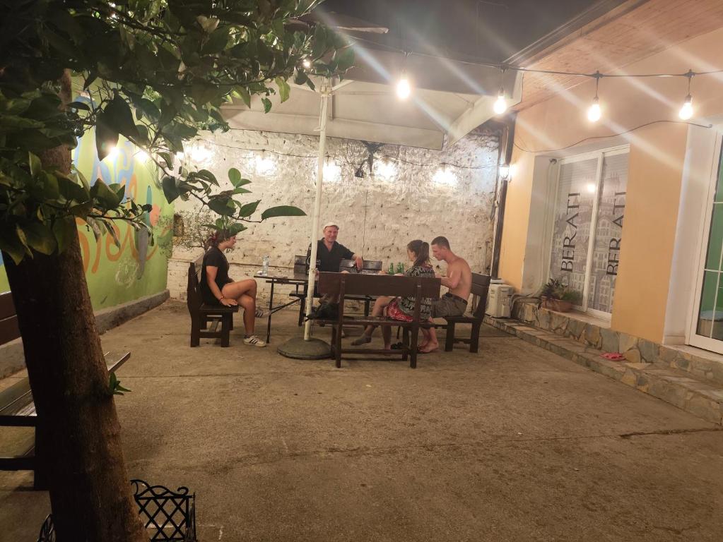 a group of people sitting at a table at night at D1 Hostel in Tirana