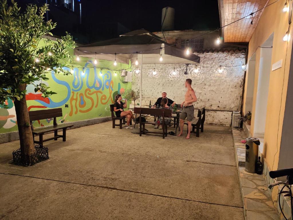 a group of people sitting at a table in a room at D1 Hostel in Tirana