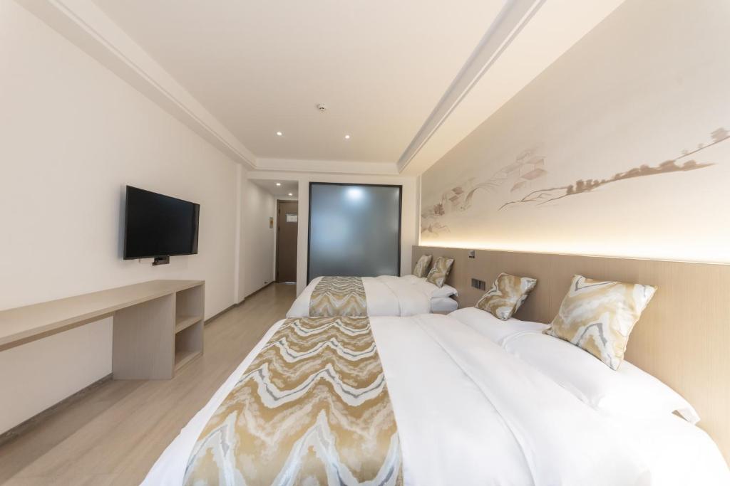 a bedroom with a large bed and a flat screen tv at 乌镇闲情逸致精品民宿 in Wujiaqiao