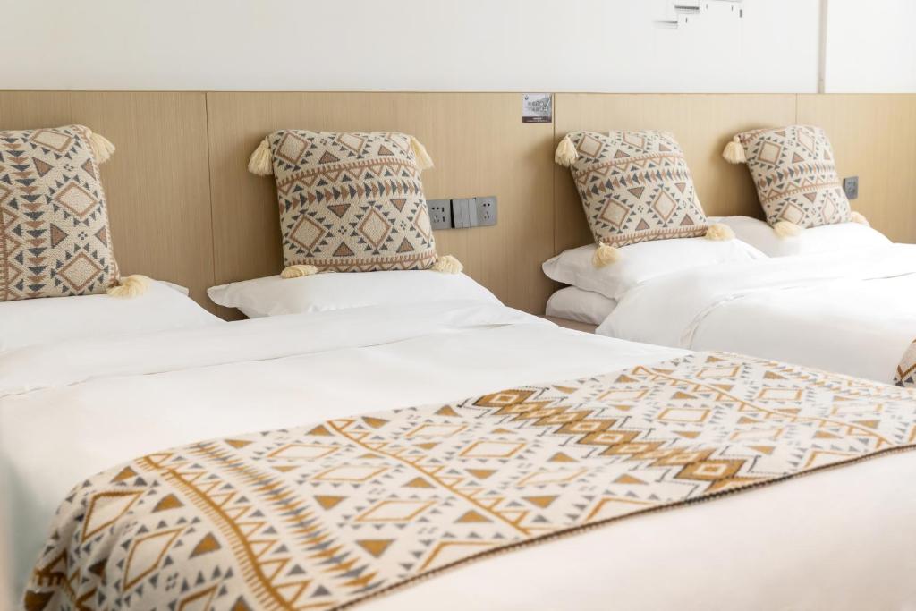 a group of three beds in a room at 乌镇闲情逸致精品民宿 in Wujiaqiao