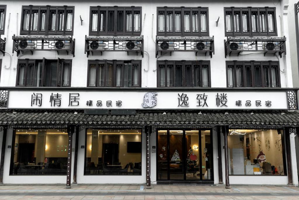 a building with chinese writing on the front of it at 乌镇闲情逸致精品民宿 in Wujiaqiao