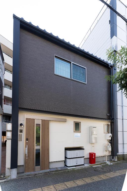 a black and white building with a door at 鱗町庵 in Kanazawa