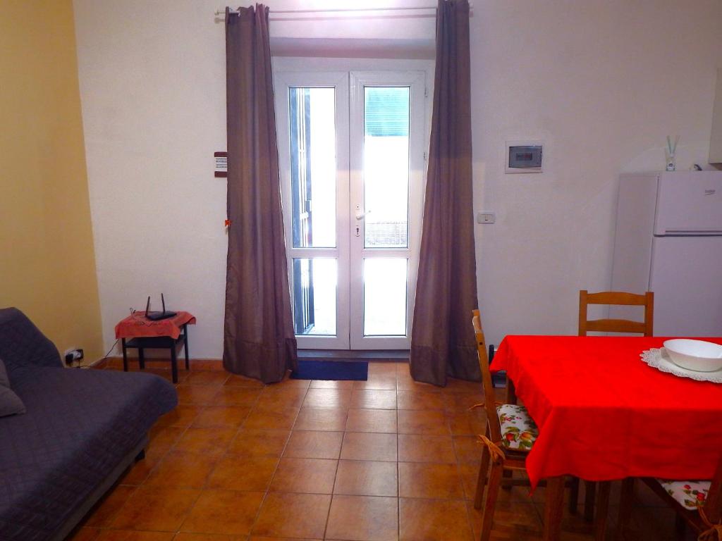 un soggiorno con tavolo e tovaglia rossa di Holiday Home Ettore a Catania
