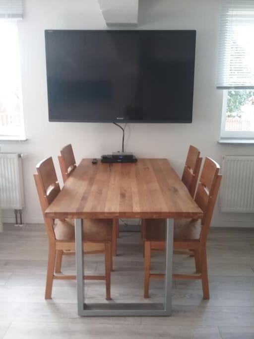 a wooden table with chairs and a flat screen tv at Ferienwohnung OT Meersburg in Grasbeuren