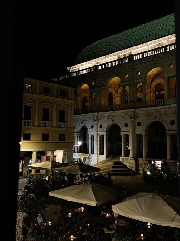 a large building with tables and umbrellas in front of it at Centro storico apartment in Vicenza