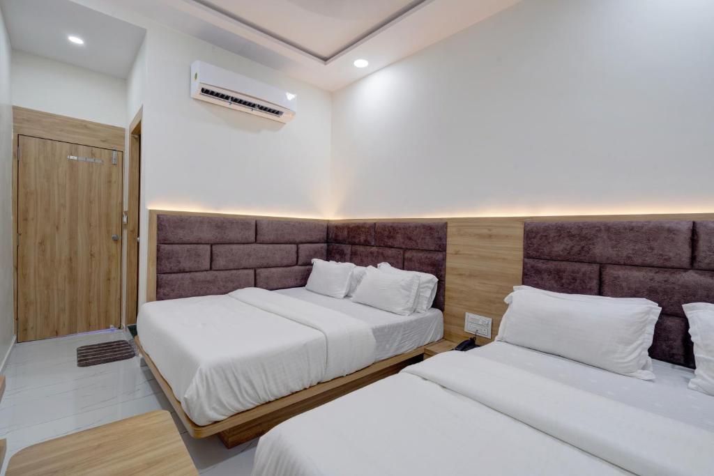 Postel nebo postele na pokoji v ubytování Hotel Apple View,Ahmedabad