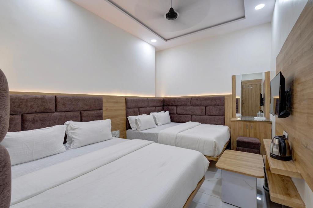 Postel nebo postele na pokoji v ubytování Hotel Apple View,Ahmedabad