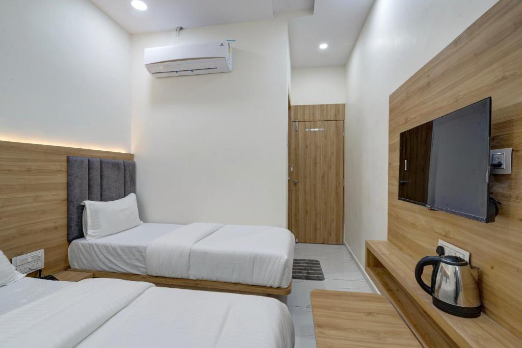 Postel nebo postele na pokoji v ubytování Hotel Apple View,Ahmedabad