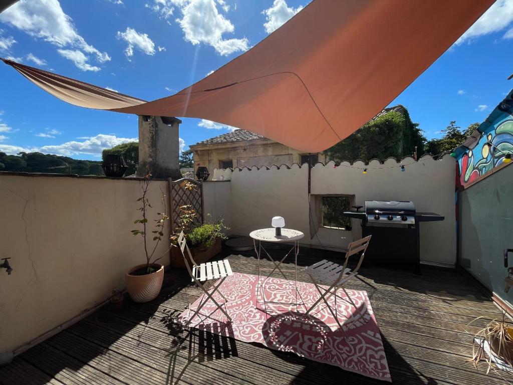 un patio avec une table, des chaises et un parasol dans l'établissement Charmante maison de village, à Collias