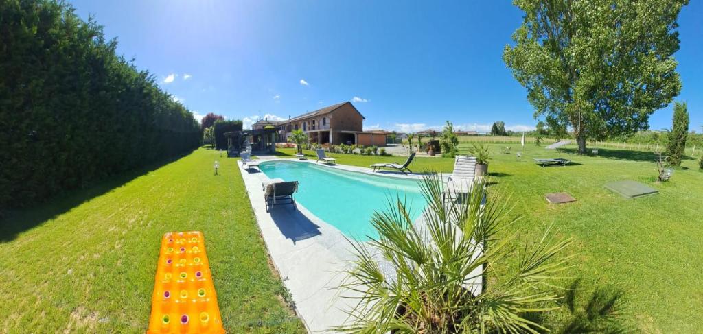 a swimming pool with a bench next to a house at Anticopodere in Casorzo