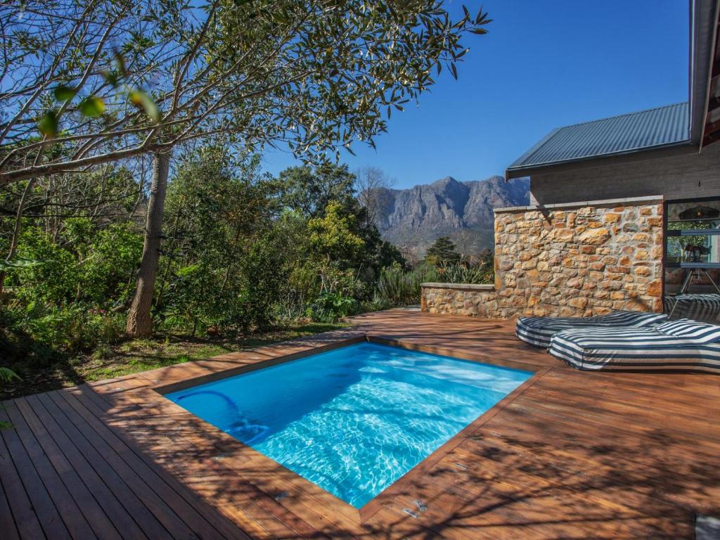 a swimming pool on a deck next to a house at Wechmarshof in Stellenbosch