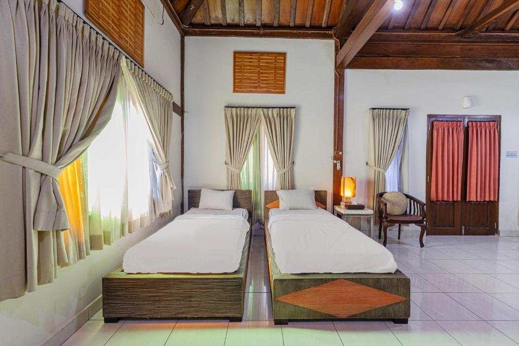 Postel nebo postele na pokoji v ubytování Pondok Gajah Hotel