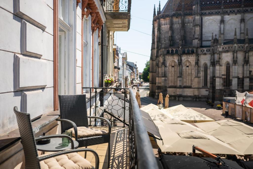 a balcony with tables and chairs on a city street at Luxapart II Beautiful Views with Breakfast option in Košice