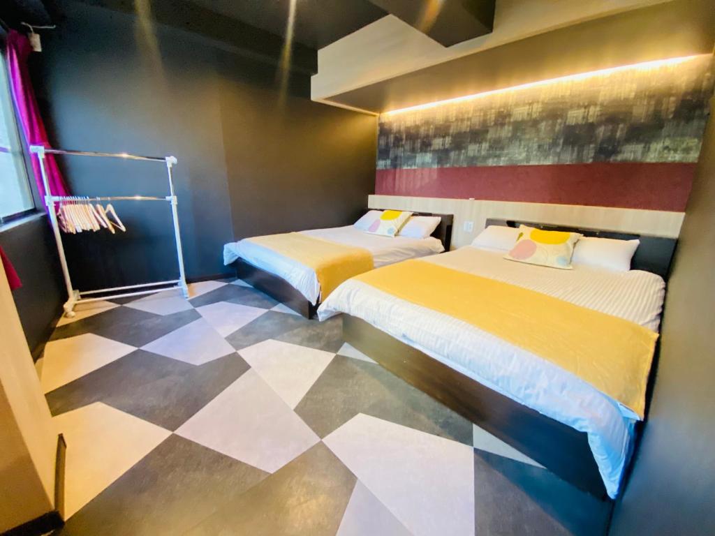 two beds in a room with a checkered floor at Asakusa-Smile-SM0141 in Tokyo