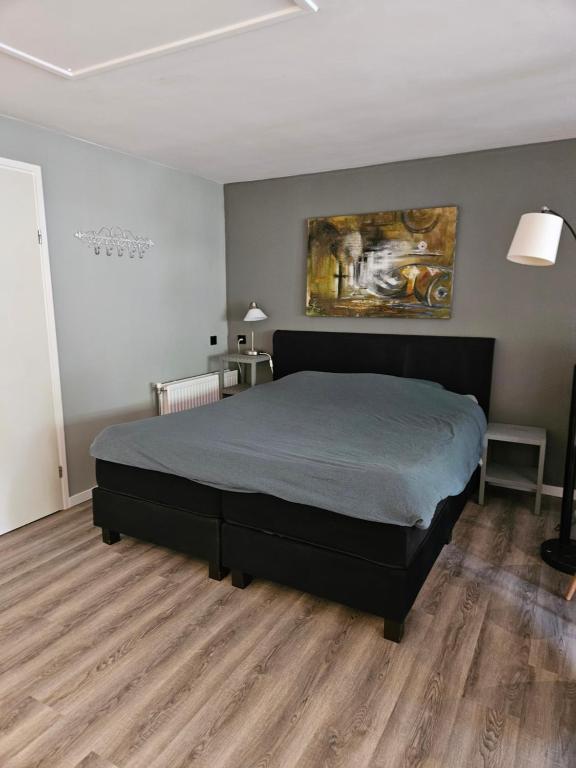 een slaapkamer met een bed en een schilderij aan de muur bij Het Atelier in Almelo