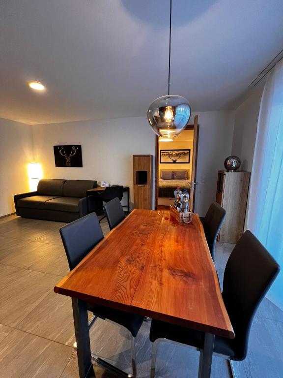 マローヤにあるCervo Apartの木製のテーブルと椅子のあるリビングルーム