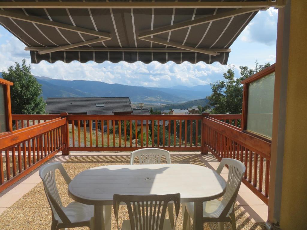 un patio avec une table et des chaises sur une terrasse dans l'établissement FONT ROMEU studio cabine avec parking, à Font-Romeu