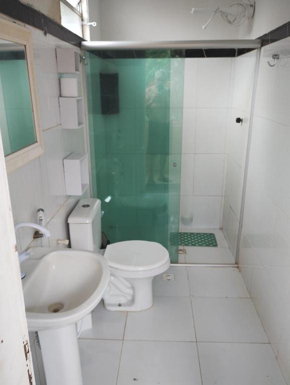 ein Badezimmer mit Dusche, Toilette und Waschbecken in der Unterkunft Sr & Sra White in Praia Da Caueira