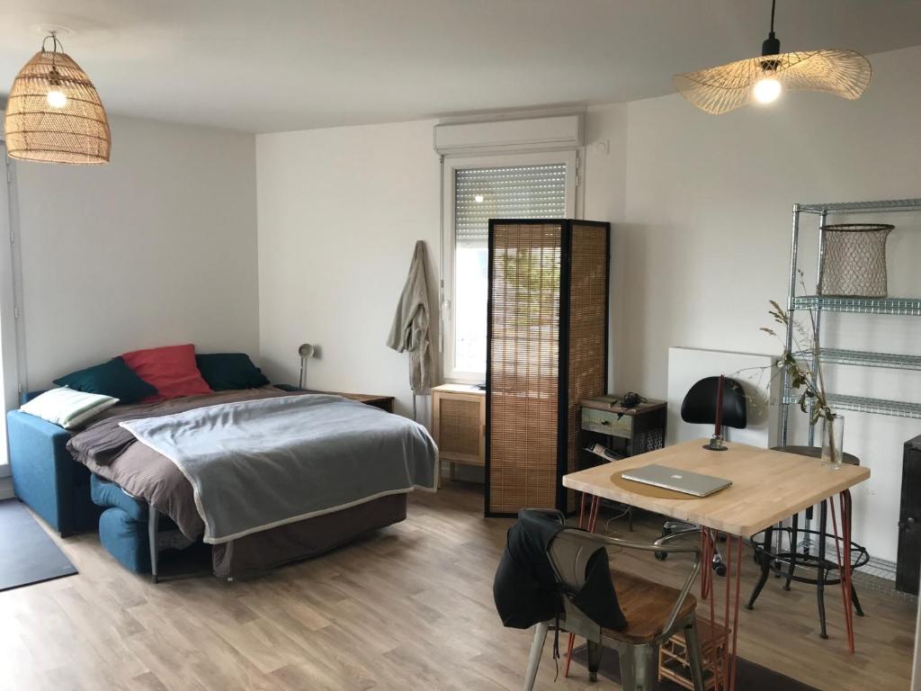 une chambre avec un lit et un bureau avec un ordinateur portable dans l'établissement Grand studio proche de Paris, à Noisy-le-Sec