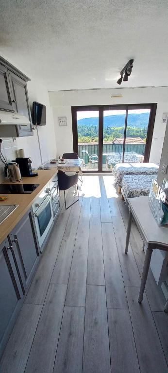 Cette chambre comprend une cuisine avec une table et un lit. dans l'établissement Studio Lou Cigaloun climatisé, à Gréoux-les-Bains