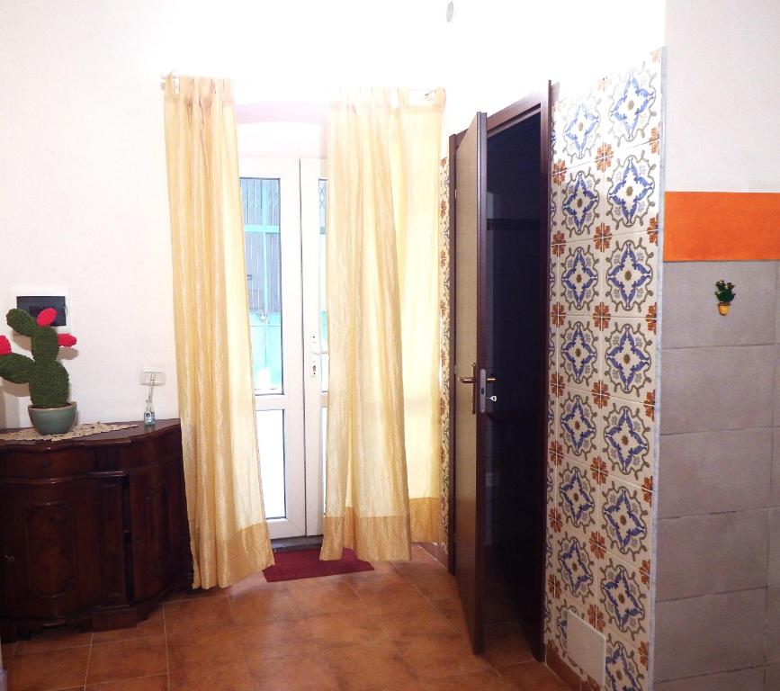 una porta aperta con tende in una stanza di Holiday Home Guglielmo a Catania