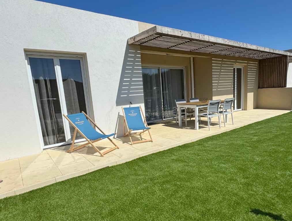 d'une terrasse avec des chaises et une table sur une pelouse. dans l'établissement Guedins'House, à Bonifacio