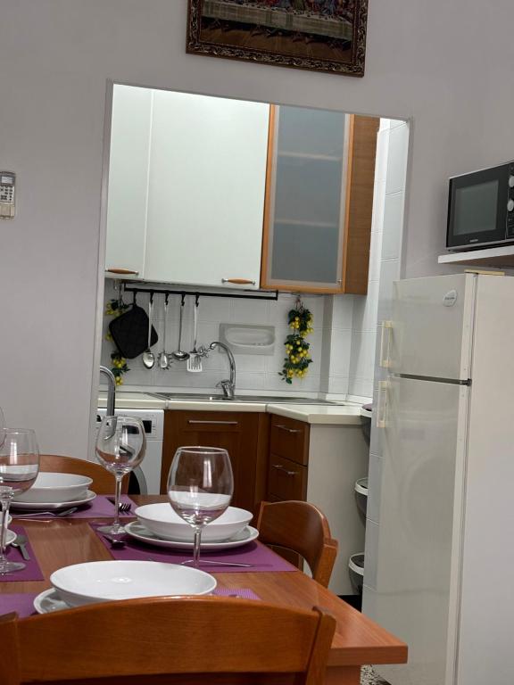 Una cocina con una mesa con copas de vino encima. en Vivi Aguilera apartament, en Bolonia