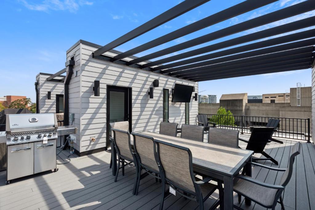 アイオワシティにあるNew Modern Townhome with Rooftop Patio townhouseのデッキにテーブルと椅子が置かれたパティオ