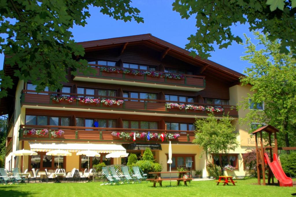 un edificio con un parque infantil delante de él en Parkhotel Kirchberg, en Kirchberg in Tirol