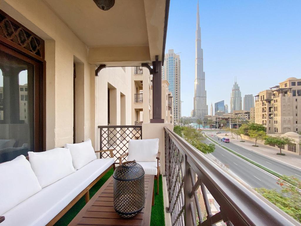 balcón con sofá y vistas a la ciudad en 5 Min Walk to Burj Khalifa 2BHK Luxury Downtown Burj Haven, en Dubái
