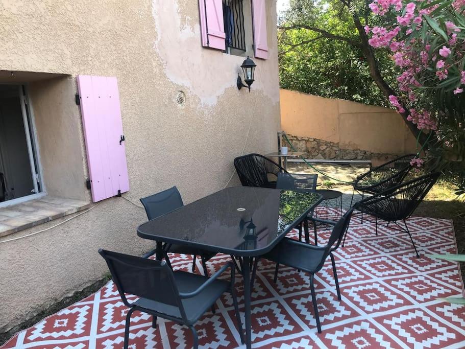 une table et des chaises assises sur une terrasse dans l'établissement Charmant studio avec jardin, à Cannes