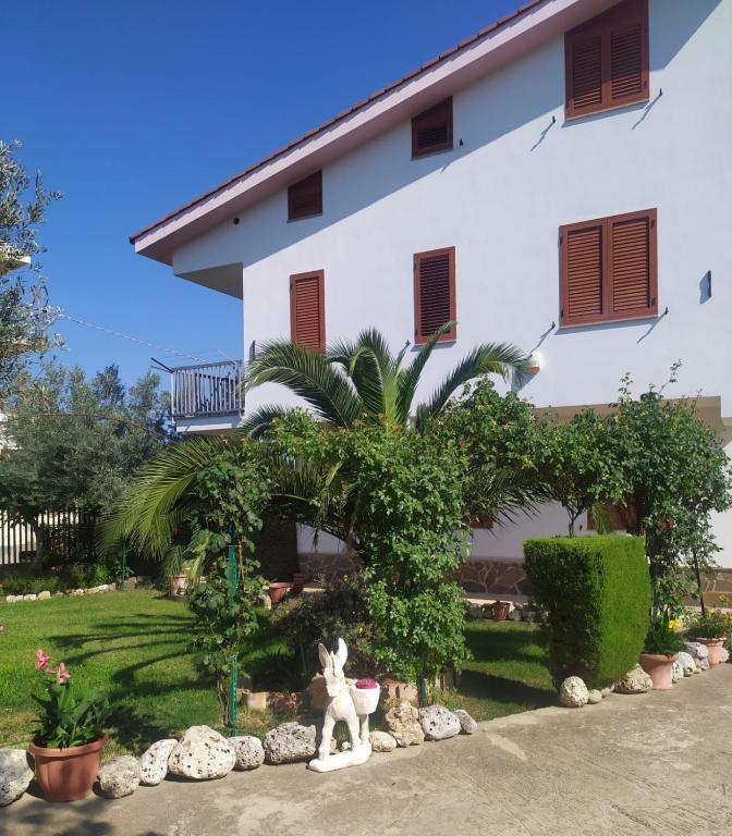 a house with a statue in front of it at Casa Vacanze Il Roseto in Roseto Capo Spulico