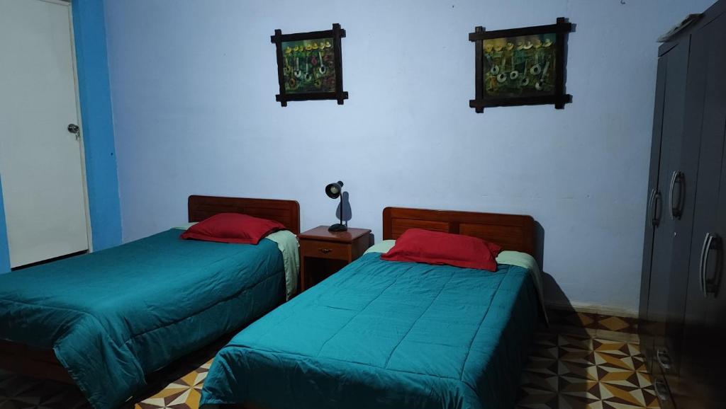 zwei Betten in einem Zimmer mit blauen Wänden in der Unterkunft Casa El Capulí in Cajamarca