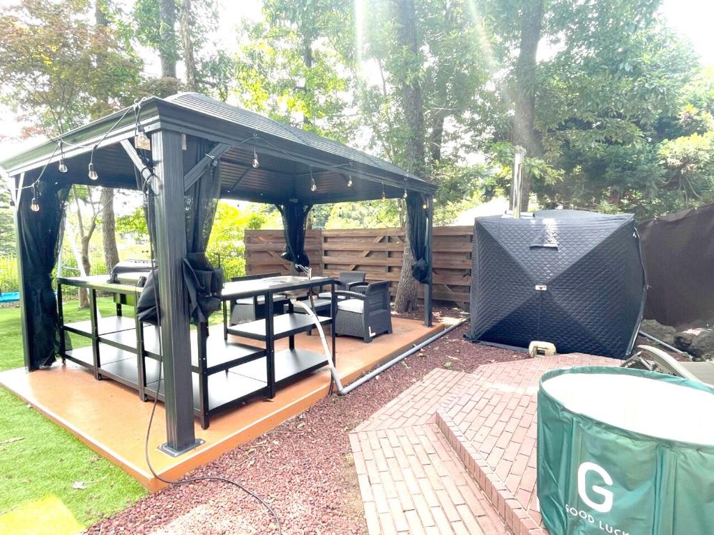 a gazebo with a picnic table and a grill at 高原エール#サウナ #海に近い #温泉 #遊具 #雨でもバーベキュー #Wi-Fi in Futo