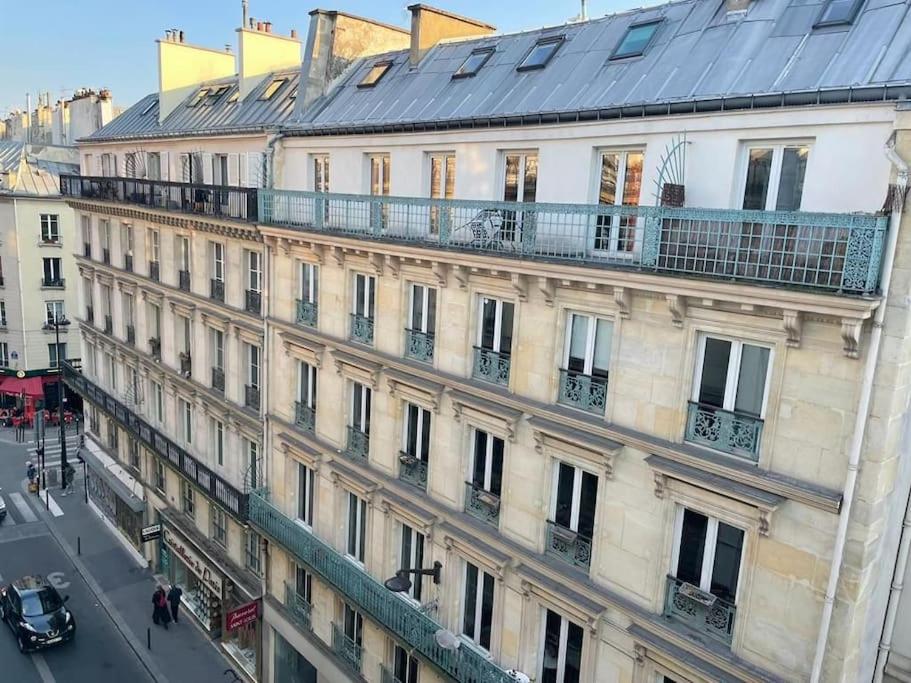 un bâtiment avec un balcon au-dessus dans l'établissement joli studio bohème sous les toits de Paris, à Paris