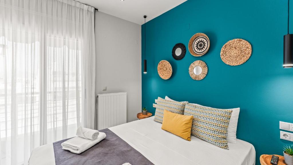 a blue bedroom with a bed and a blue wall at Creticum Suites in Heraklio
