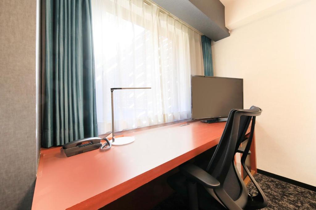 a desk with a computer on it with a window at Richmond Hotel Yokohama-Bashamichi in Yokohama