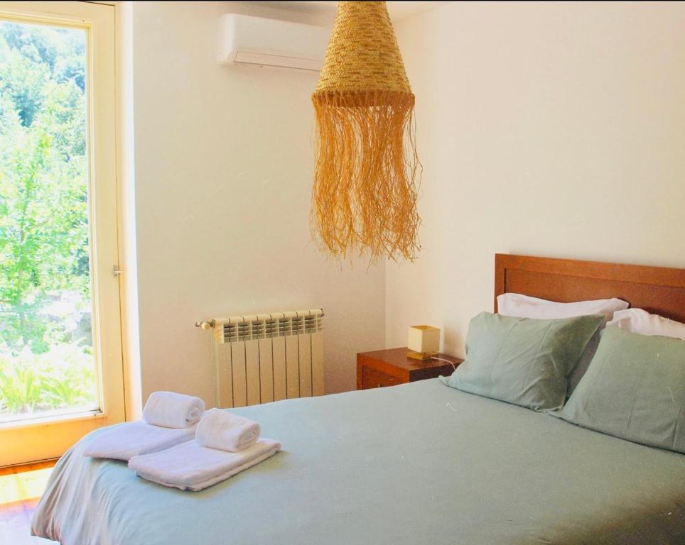 a bedroom with a bed with towels on it at Gerês - Casa da Cabana in Vieira do Minho