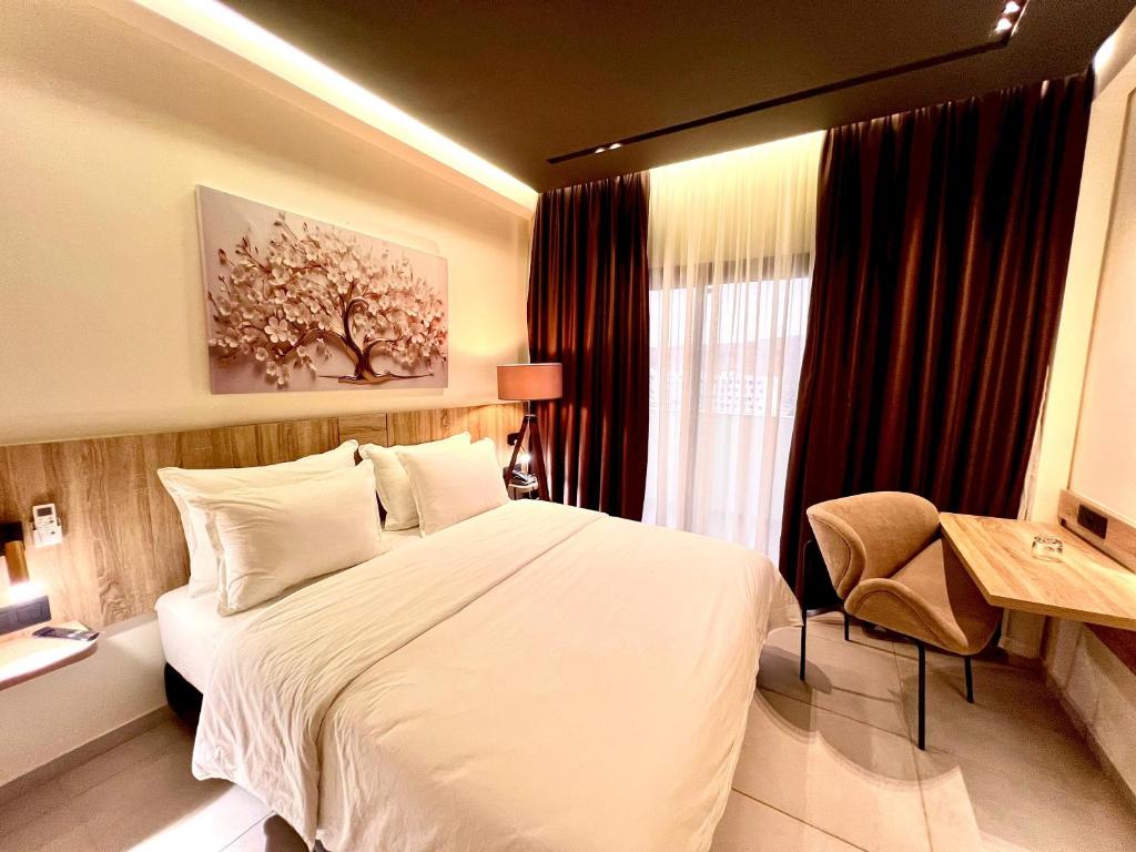 塔扎Hôtel Le Manoir的卧室里有一张白色的大床和一扇窗户