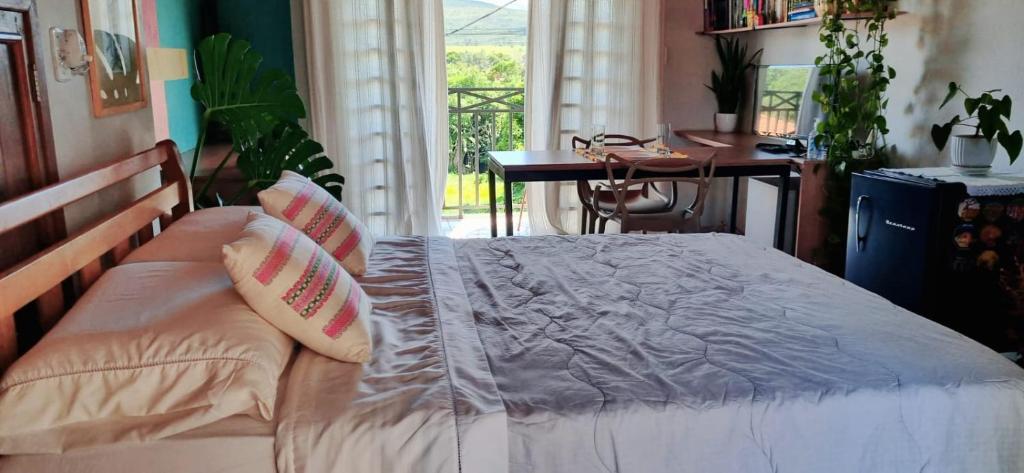 una camera con letto con cuscini e scrivania di Estúdio Florarte a Carrancas