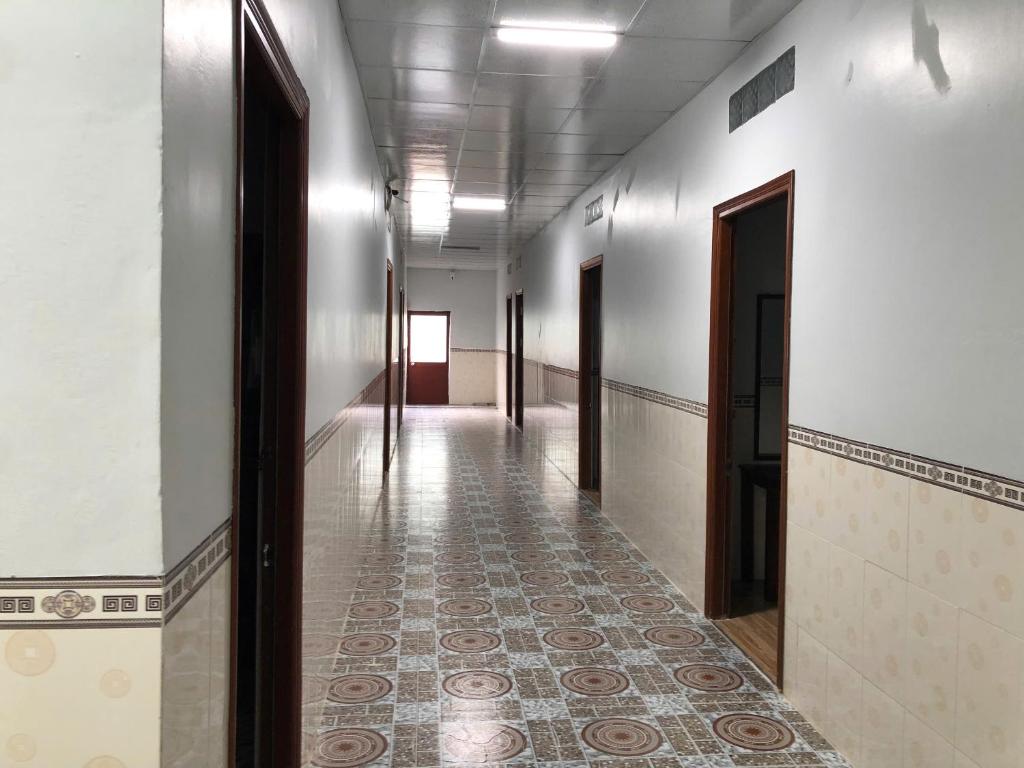 an empty hallway with a tile floor and doors at Nhà Nghỉ THANH LIÊM in Cà Mau
