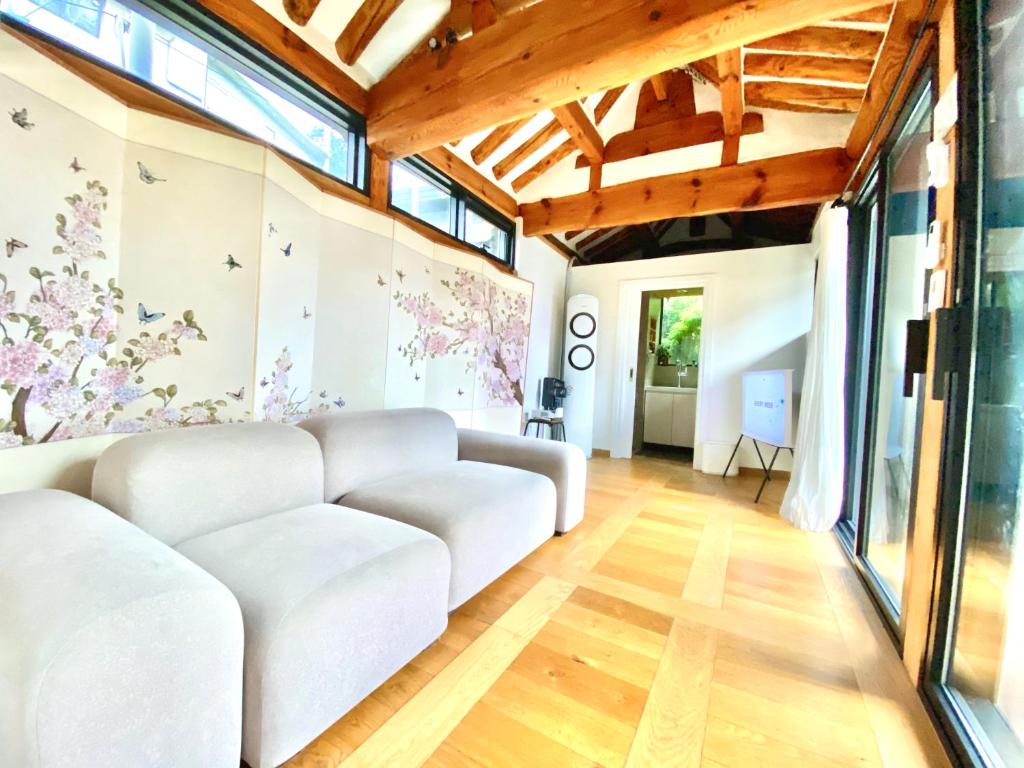sala de estar con sofá blanco y ventanas en Hanok JADE, en Seúl