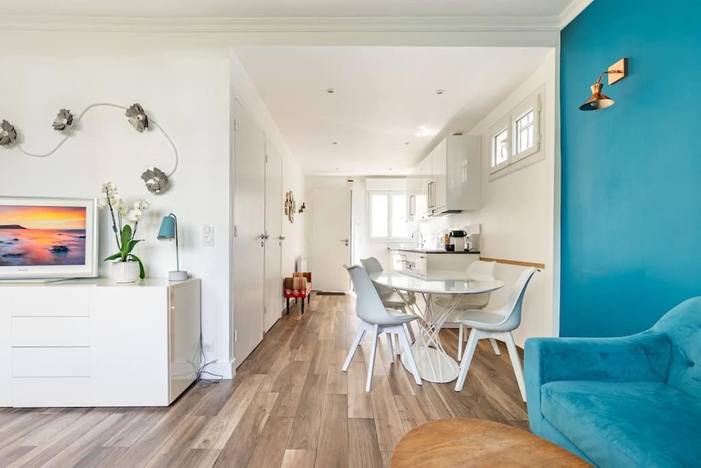 ein Wohnzimmer mit einer blauen Wand, einem Tisch und Stühlen in der Unterkunft Paris La Defense - Refurbished independent house in La Garenne-Colombes