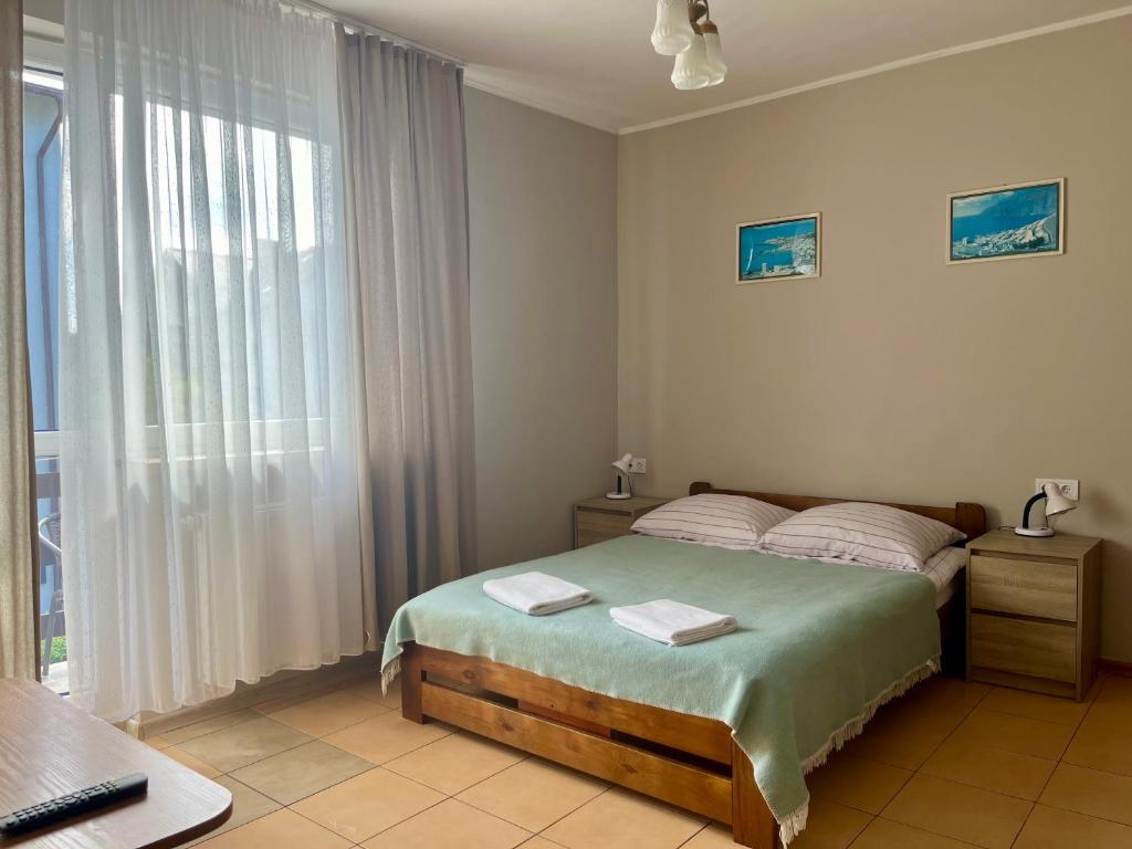 Un dormitorio con una cama y una ventana grande. en Willa Tina, en Karwia