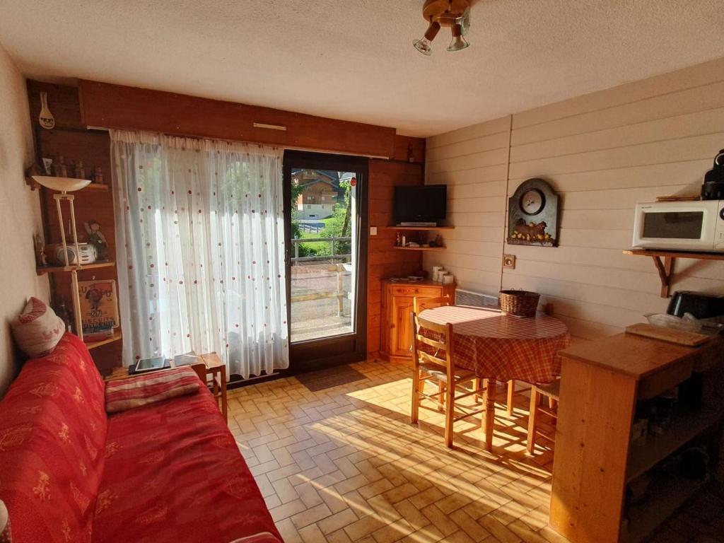 un salon avec un canapé et une table dans l'établissement Appartement cosy à Châtel, 100m des pistes, 4 pers., terrasse sud, équipements cuisine complets - FR-1-676-185, à Châtel