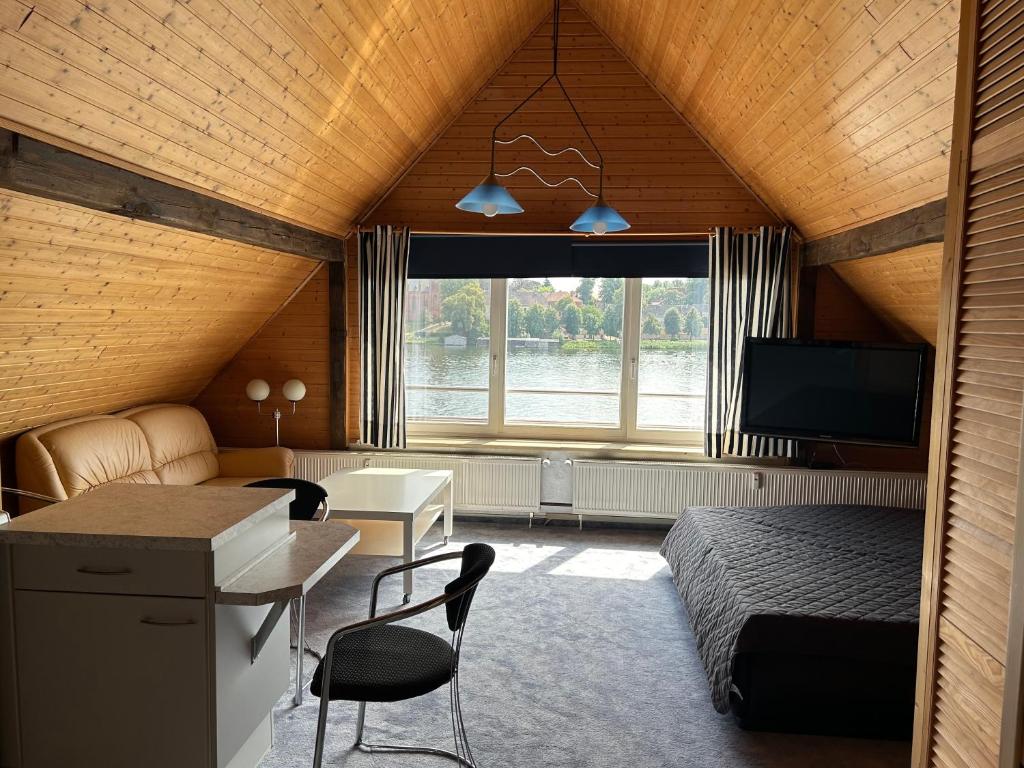 a room with a bed and a desk and a television at Ferienwohnung Insel Malchow mit eigenem Bootsanleger in Malchow